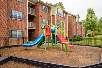 A playground with a blue slide and red and yellow stairs.